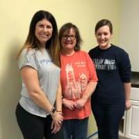 Three volunteers pose for a photo together at Positive Options for Community Outreach Week.